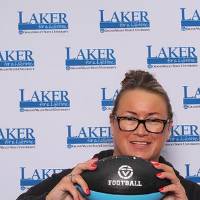 Alumna holding up football